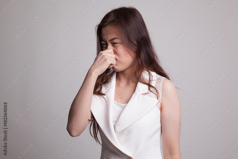 Young Asian woman holding her nose because of a bad smell. Young Asian woman holding her nose because of a bad smell.