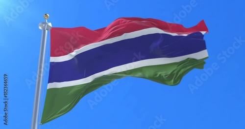 Flag of the Gambia waving at wind in slow in blue sky, loop photo