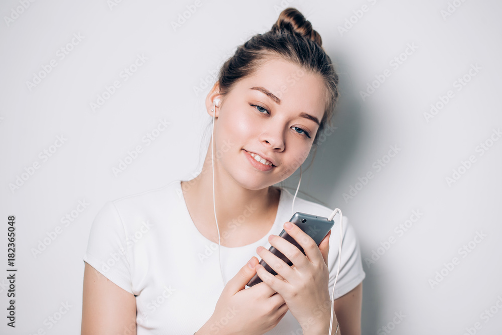 Happy young fit woman using cell phone while listening to music on smartphone Happy young fit woman using cell phone while listening to music on smartphone