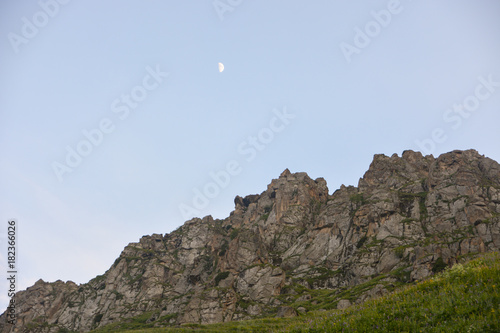 Rocky against blue sky and beautiful  crescent in evening