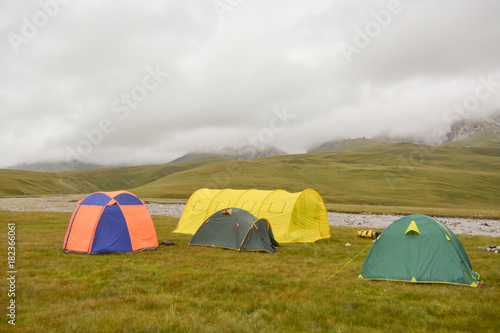 Tourist tent in field camp among montains