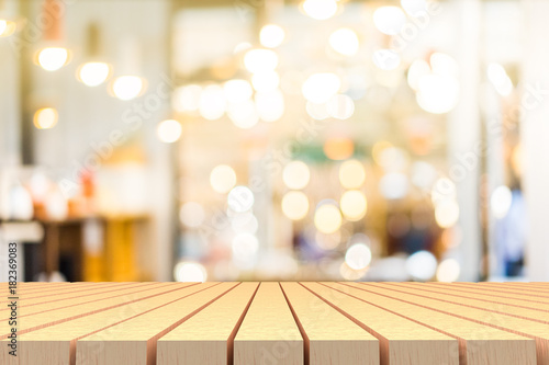 Selective focus of wooden table in front of decorative indoor string lights. Christmas  festival and holiday concepts  can used for display or montage your products.