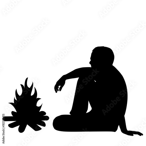 Silhouette of male tourist sitting near fire