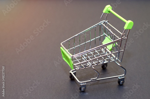 Empty shopping cart on a black background. The concept of shopping in the supermarket