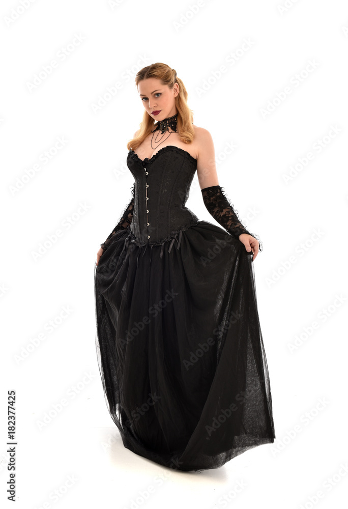 full length portrait of a blonde girl wearing black gothic gown. standing pose, isolated on white background. full length portrait of a blonde girl wearing black gothic gown. standing pose, isolated on white background.