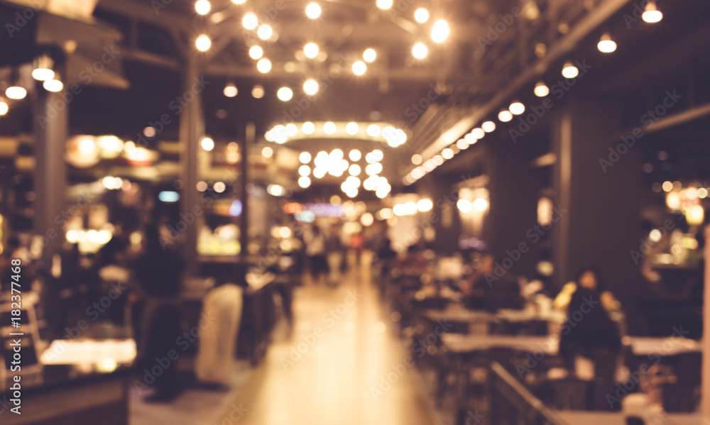 Blur of people in night cafe with lighting bokeh