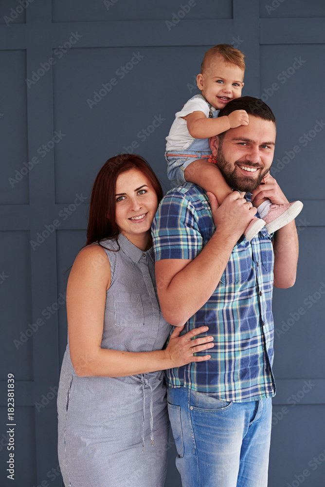 Smiling couple with little daughter posing at camera in studio Smiling couple with little daughter posing at camera in studio