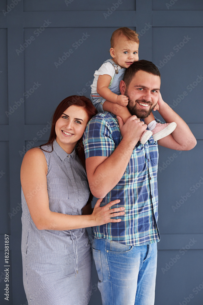 Lovely couple posing with small daughter in studio Lovely couple posing with small daughter in studio