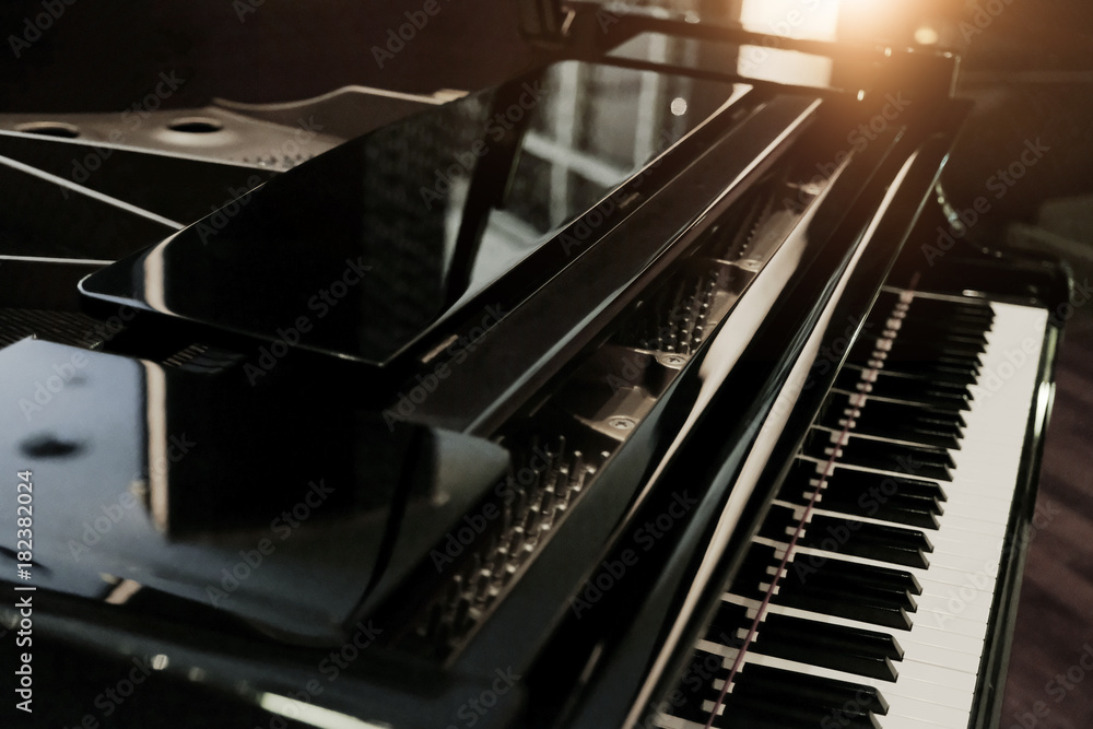 Fototapeta Czarny błyszczący fortepian z białą klawiaturą w ciemnym tonie