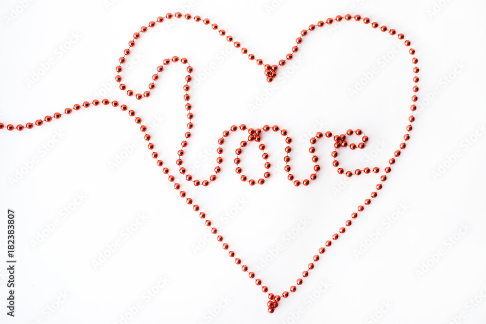 The word LOVE and symbol heart- declaration of written with red beads isolated on white background The word LOVE and symbol heart- declaration of written with red beads isolated on white background