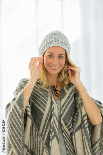 beautiful woman trying new wolly hat at home