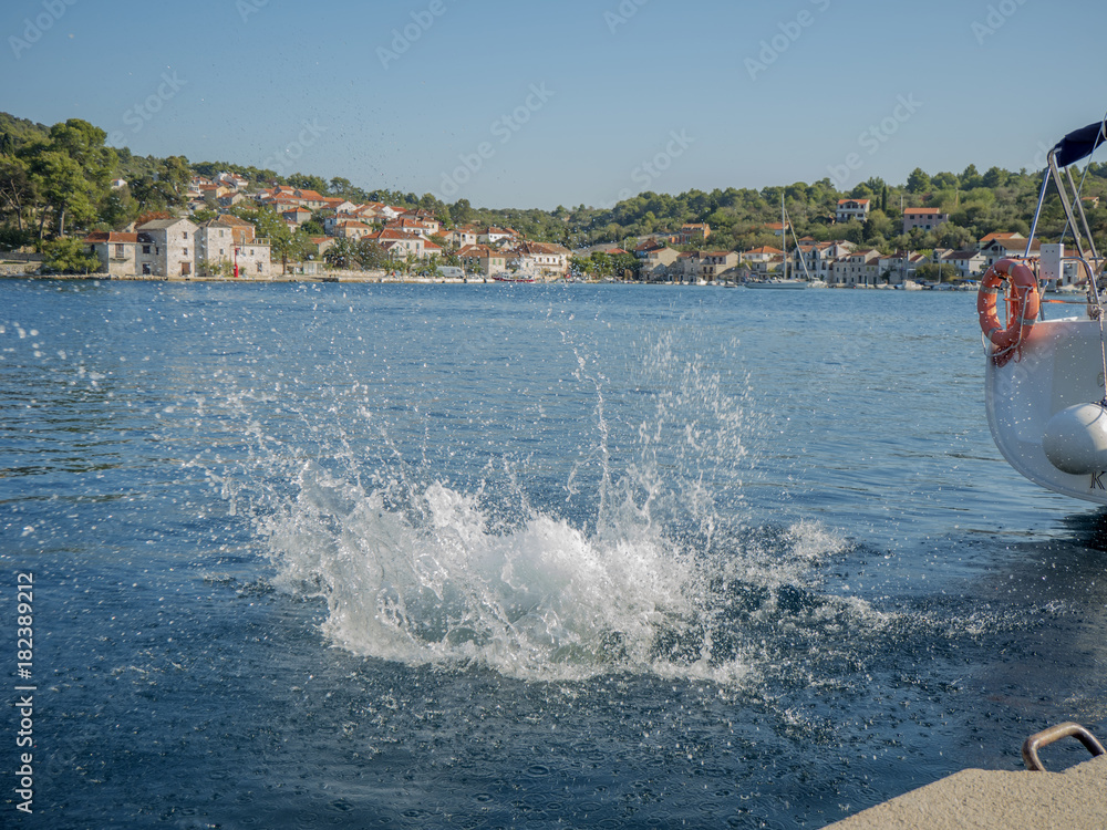 Sea splash from man jumping in water.