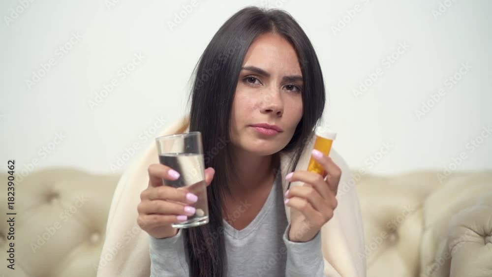 Wide spread infection. Unhealthy young woman going to take drugs while sitting on the couch Wide spread infection. Unhealthy young woman going to take drugs while sitting on the couch