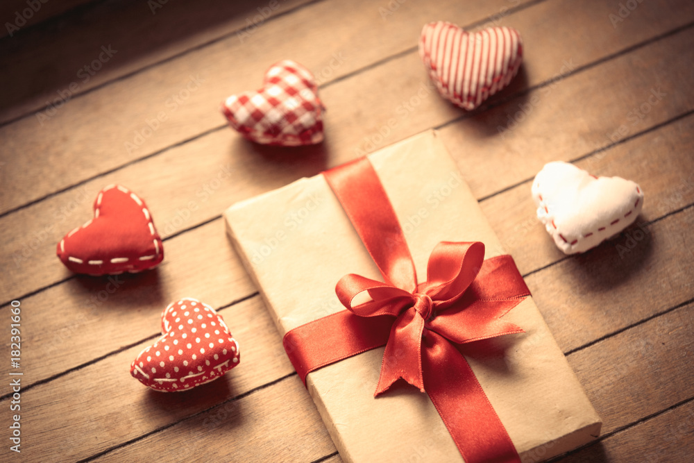 Heart shape toys and gift box on wooden background Heart shape toys and gift box on wooden background