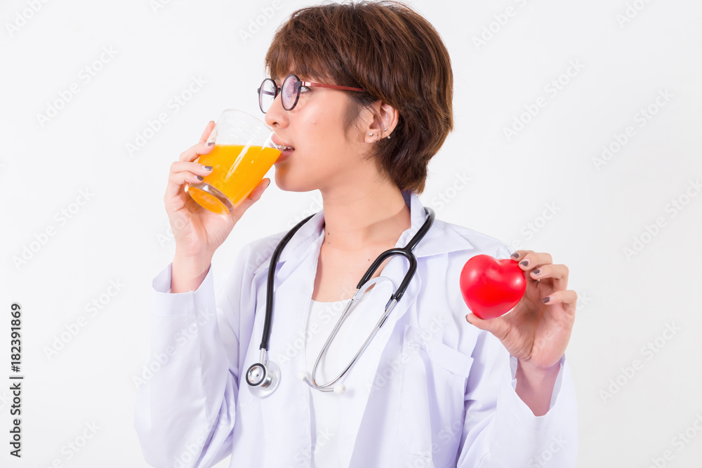 Happy woman doctor holding the red heart and orange juice. Isolated on white background. Studio lighting. Concept for healthy and medical Happy woman doctor holding the red heart and orange juice. Isolated on white background. Studio lighting. Concept for healthy and medical