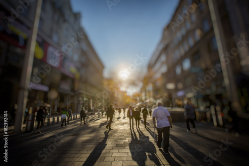 Crowd of anonymous people walking on busy city street, urban life background