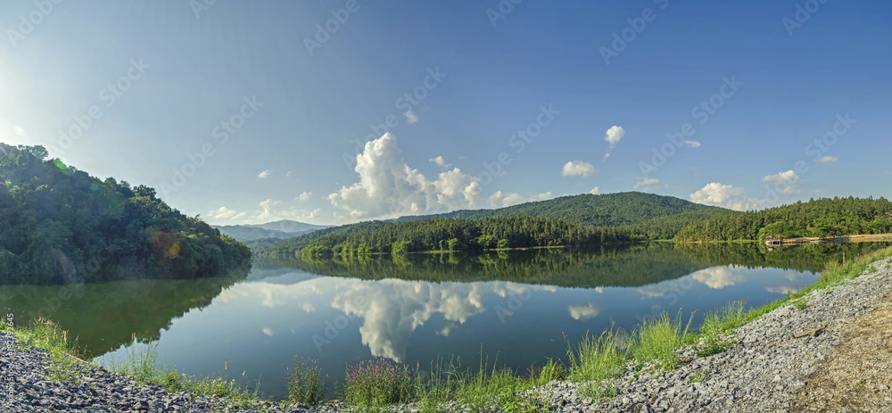 Obraz premium Panorama of the dam and lake on the mountain with tree and forest and the rock with beautiful blue sky and clouds on sunshine day.