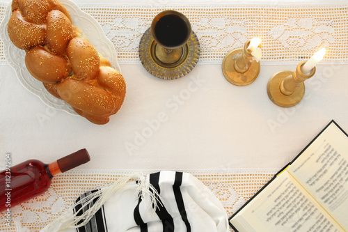 shabbat image. challah bread, shabbat wine and candles on the table. Top view. photo