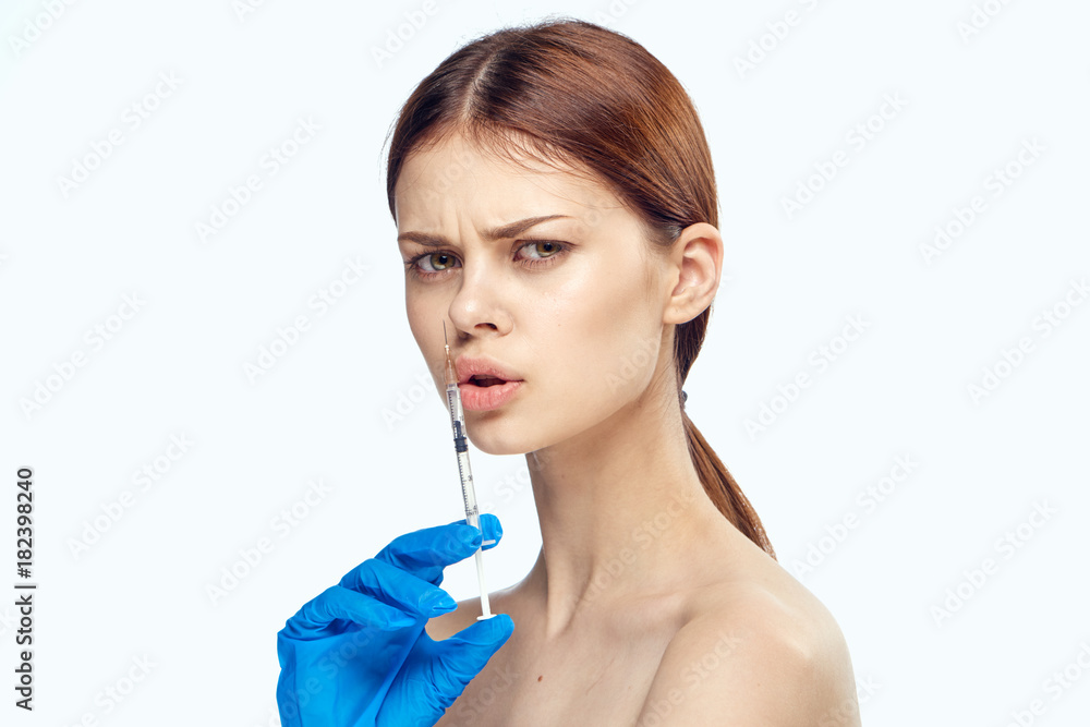 Young beautiful woman in gloves holds a syringe on white isolated background, medicine Young beautiful woman in gloves holds a syringe on white isolated background, medicine