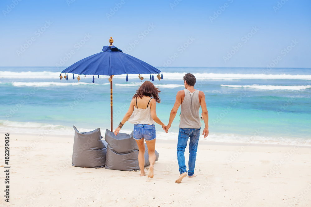 Back view shot of a couple in resort on a beach in Bali