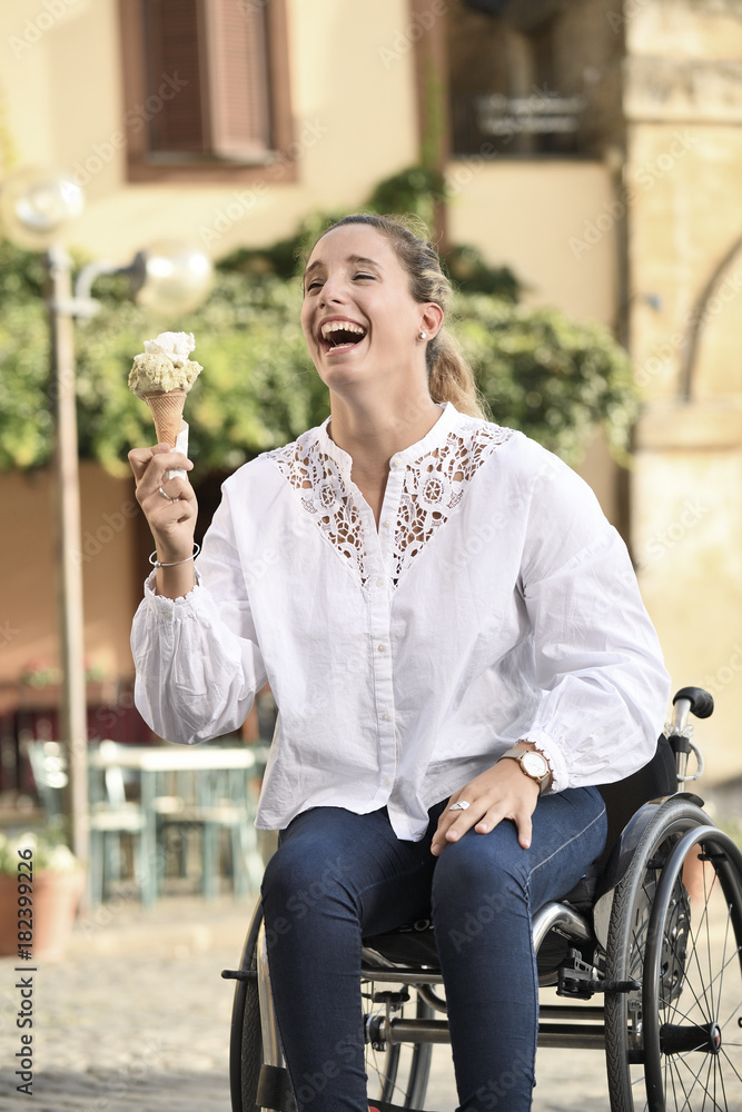 Ragazza allegra in sedia a rotelle con gelato Stock Photo | Adobe Stock