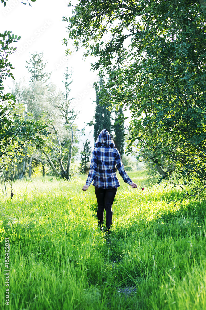 The concept of enjoying nature. Girl in a hooded shirt