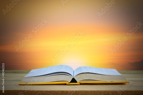 Wisdom, education and knowledge concept, book on table with twilight background .
