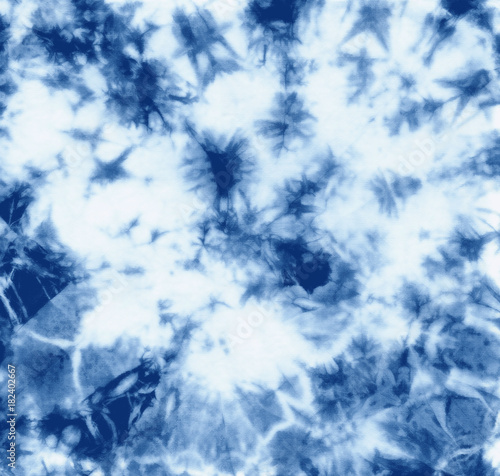 Abstract tie dyed fabric of indigo color on white cotton. Hand painted fabrics. Shibori dyeing photo