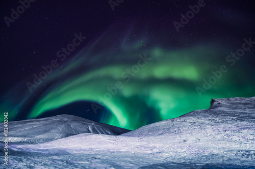 The polar arctic Northern lights aurora borealis sky star in Norway Svalbard in Longyearbyen city the moon mountains