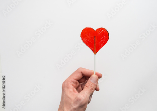 Hand holding shape of heart stick candy, love concept