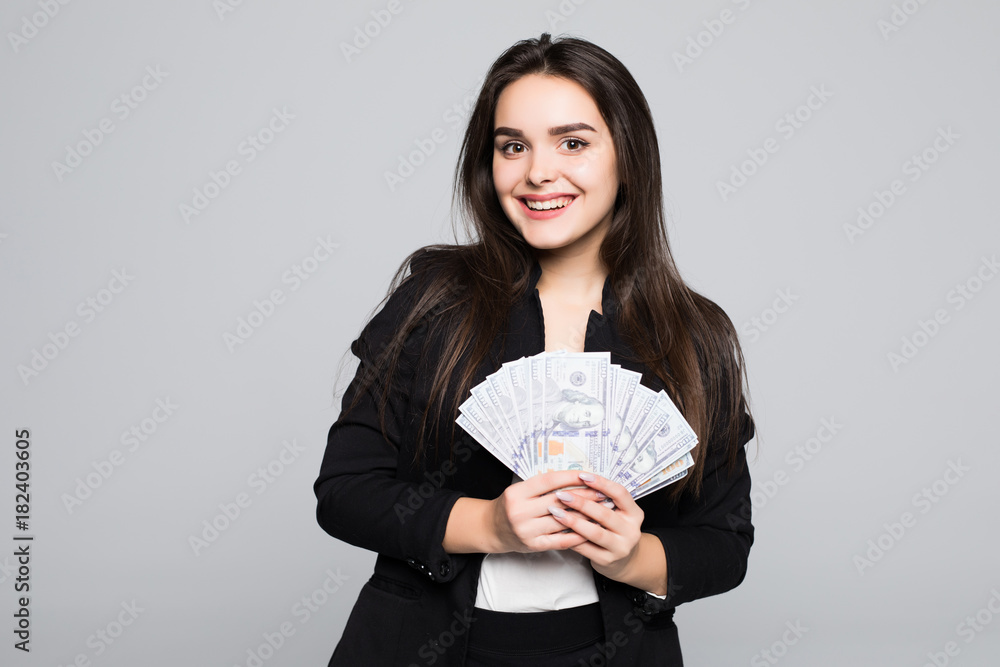 Smiling business woman holding money over gray background Smiling business woman holding money over gray background