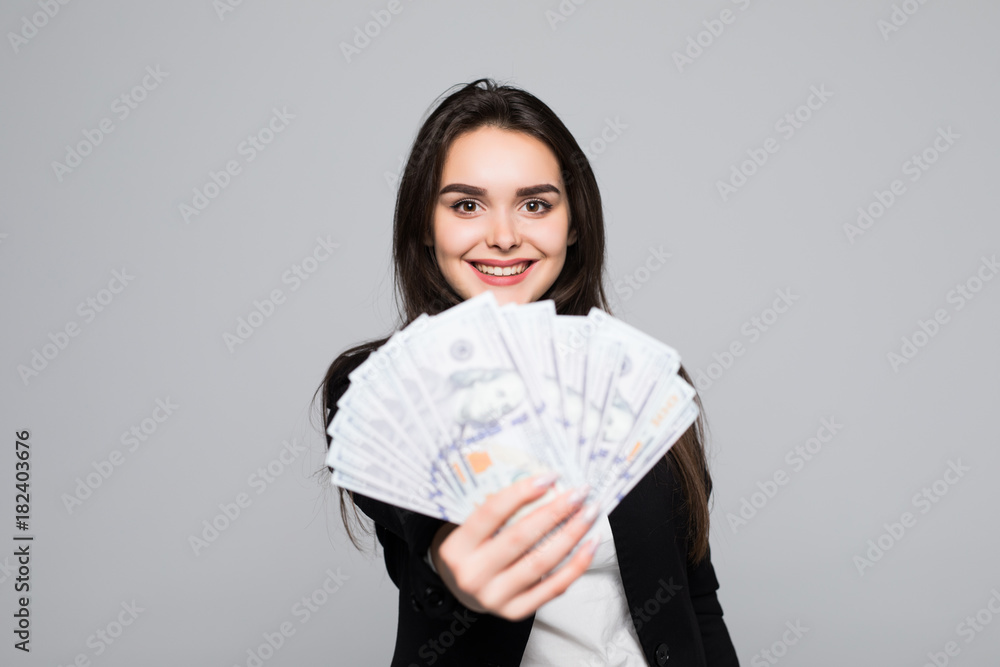 Smiling business woman holding money over gray background Smiling business woman holding money over gray background