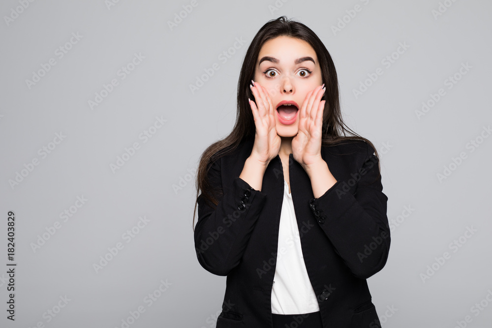 Young woman screaming with wide open mouth isolated on gray wall background Young woman screaming with wide open mouth isolated on gray wall background