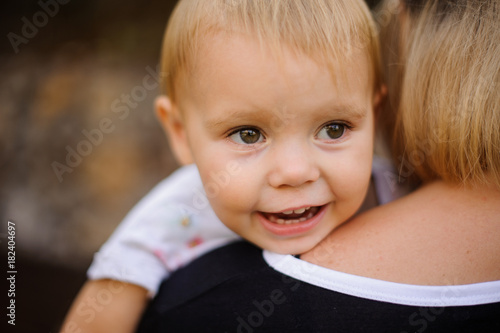 Smiling cute baby lying on mom s shoulder