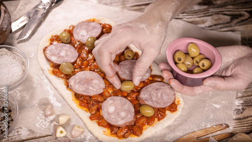 Female hands make home-made pizza. Home-made pastries and cooking