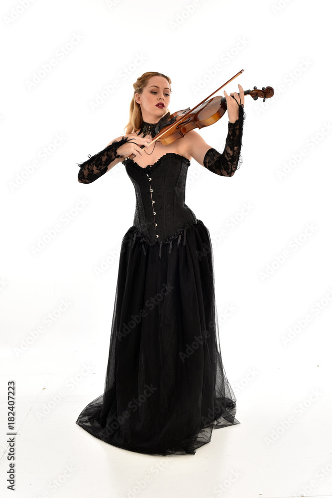 full length portrait of a blonde girl wearing black gothic gown. standing pose, isolated on white background. full length portrait of a blonde girl wearing black gothic gown. standing pose, isolated on white background.