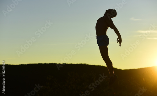 Fototapeta Naklejka Na Ścianę i Meble -  Silhouette of athlete jumping on sunset background, copy space.