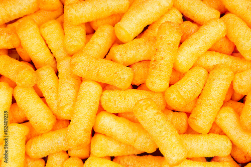 Cheese puff texture pattern background. Cheese puff snack snacks as background.