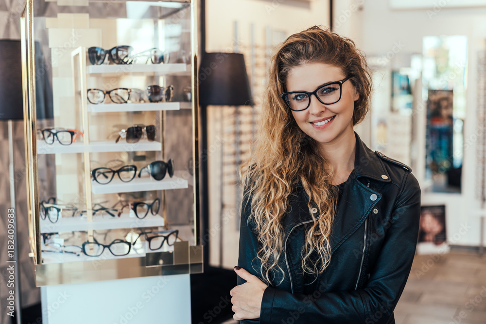 Portrait of smiling woman in optical store. Stock Photo Adobe Stock