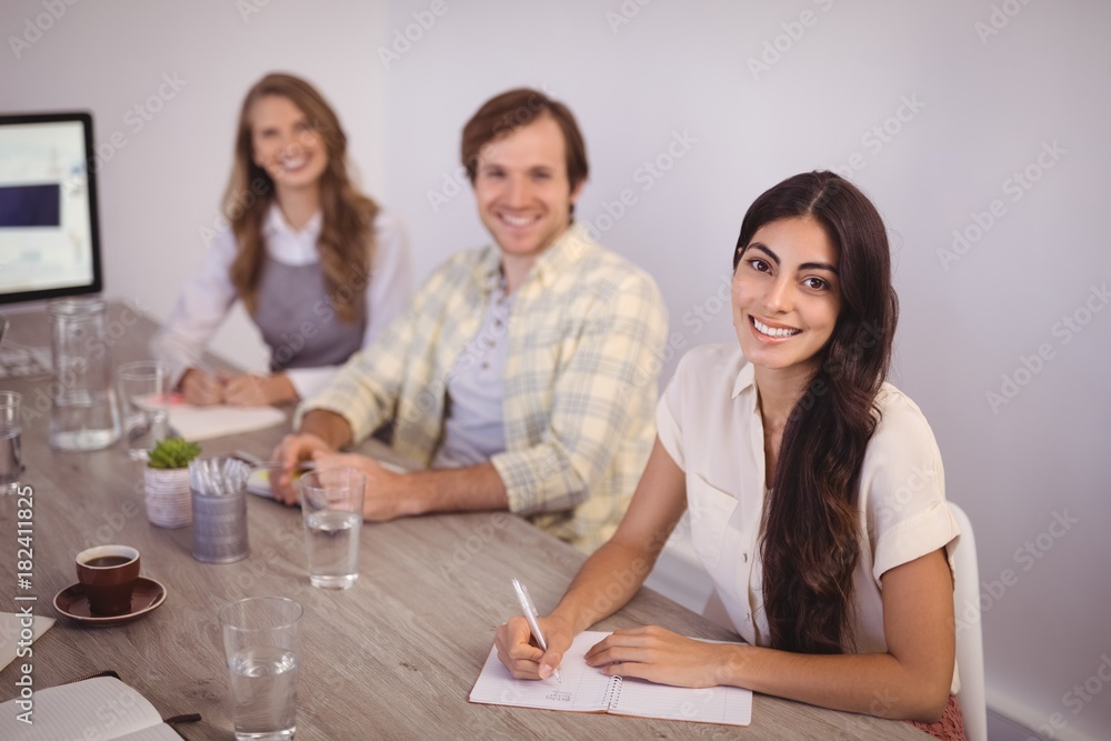 Smiling business people making notes in office Smiling business people making notes in office