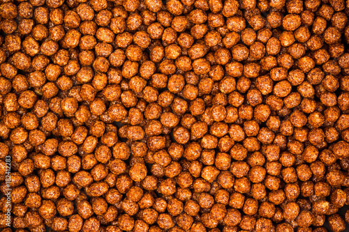 Chocolate breakfast cereal texture. Cereal balls as background. Chocolate corn balls