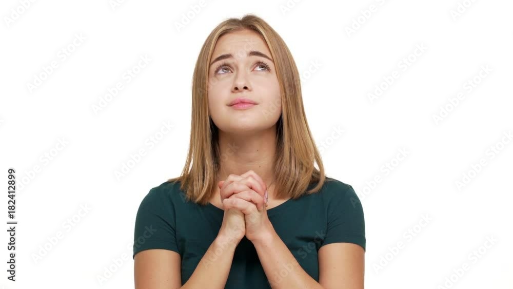 Portrait of woman looking up with keeping hands in praying begging god please wishing something strongly expressing hope and desire over white background. Concept of emotions Portrait of woman looking up with keeping hands in praying begging god please wishing something strongly expressing hope and desire over white background. Concept of emotions