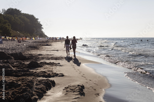 Two young women walking along the beach, Baltic Sea, Wittow Peninsula, Island of Ruegen, Mecklenburg West-Pomerania, Germany photo