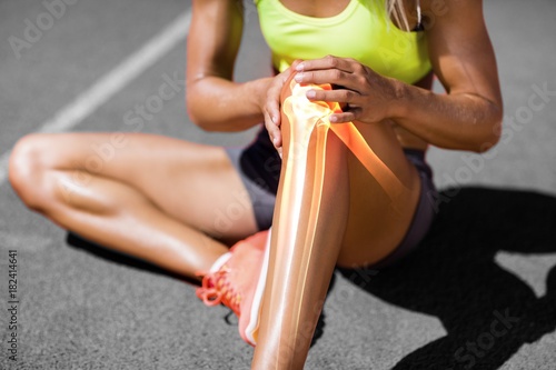 Low section of sportswoman suffering from knee pain photo