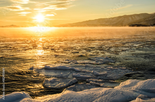 Ice floes floating on the fog water in the lake Baikal. Sunset