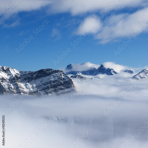 Snowy sunlight mountains in fog at nice sun day