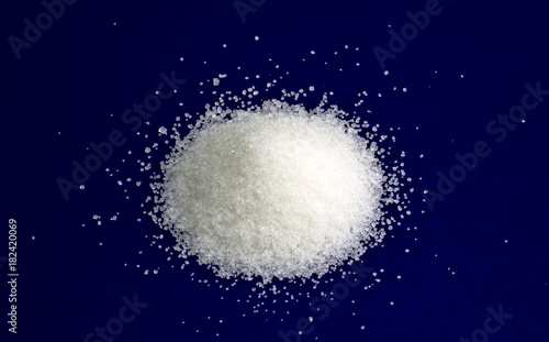 Sugar. White refined sugar on a blue background.