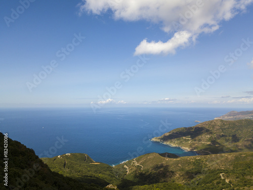 Vista aerea della costa della Corsica, strade serpeggianti e calette con mare cristallino. Penisola di Cap Corse, Corsica. Tratto di costa. Anse d'Aliso. Golfo d’Aliso. Francia