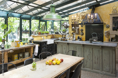 Cuisine installée dans un jardin d'hiver d'une ancienne maison et son mobilier chiné trouvé en brocante pour un style vintage