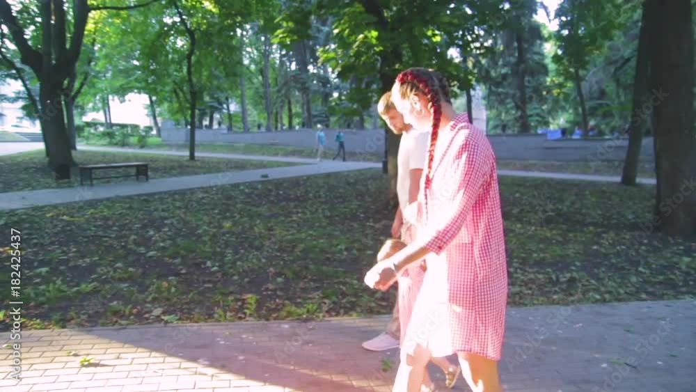 young happy family with little beautiful baby with blue eyes walking in summer park at sunset. young happy family with little beautiful baby with blue eyes walking in summer park at sunset.